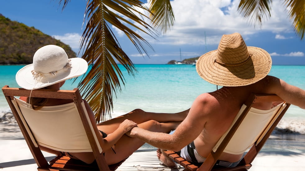 Honeymoon couple relaxing at a Caribbean beach on summer vacation